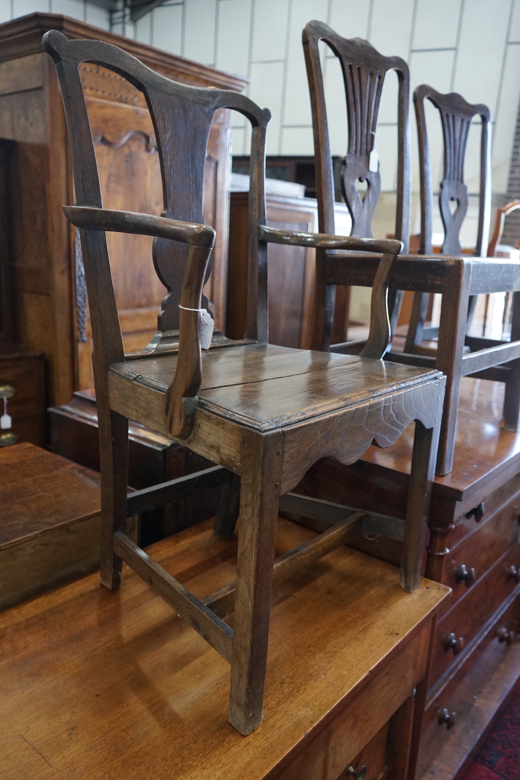 A George III oak open armchair and two similar side chairs